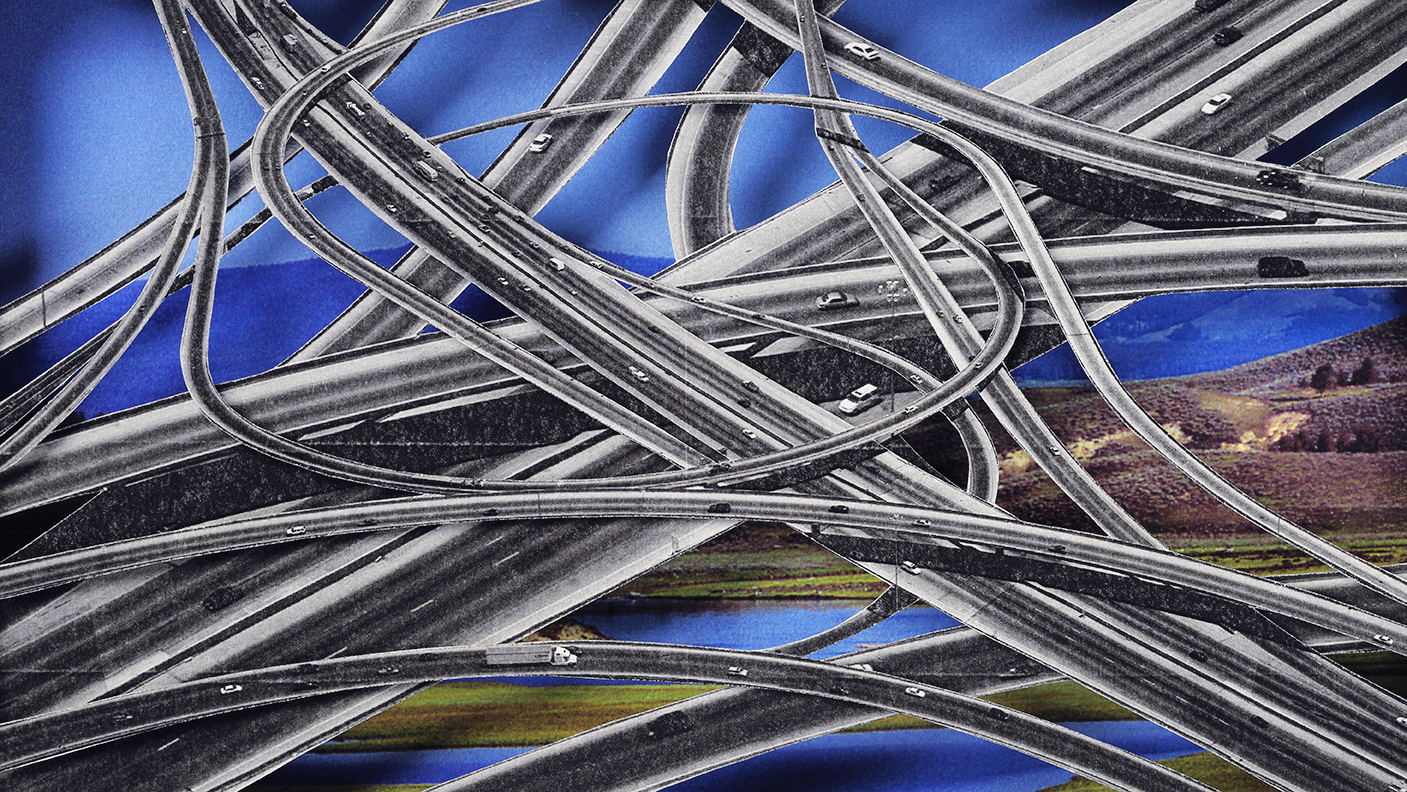 A tangle of cloverleaf road intersections covering a landscape of hills and lakes