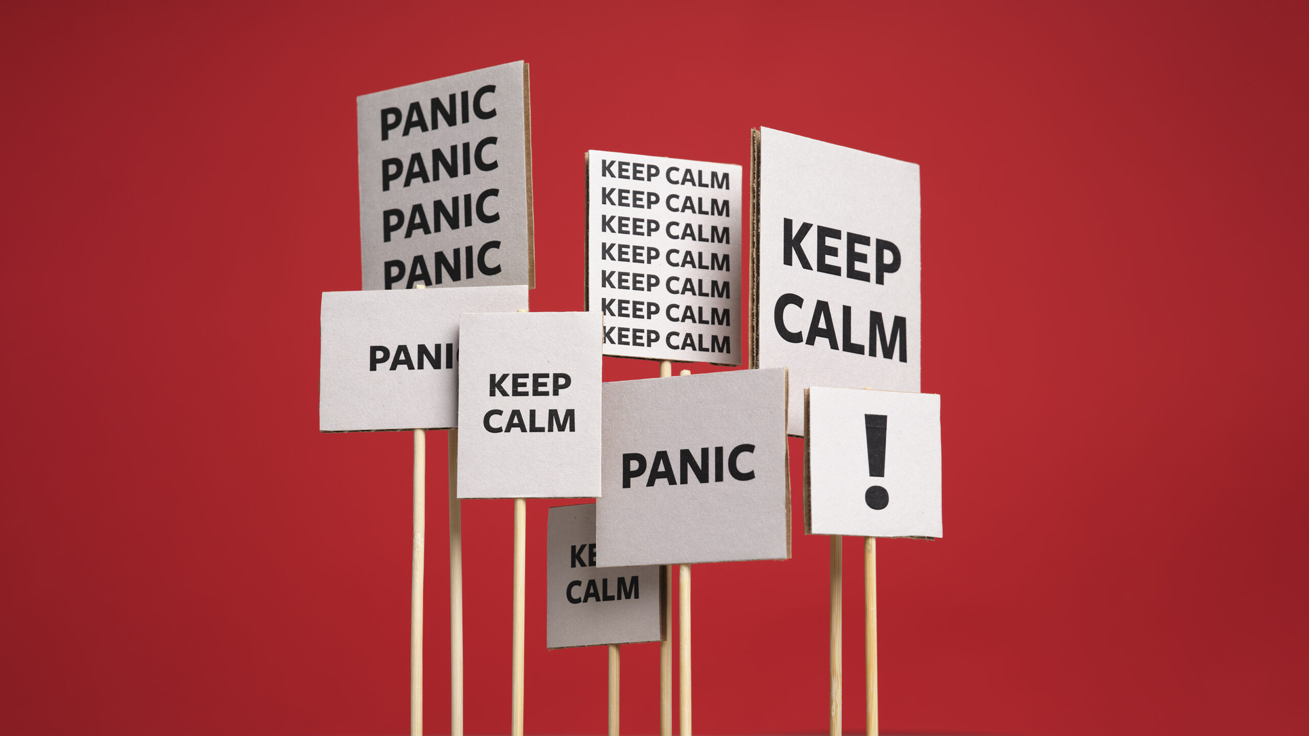 A crowd of placards with the words "Panic" and "Keep Calm" on them, against a red background.