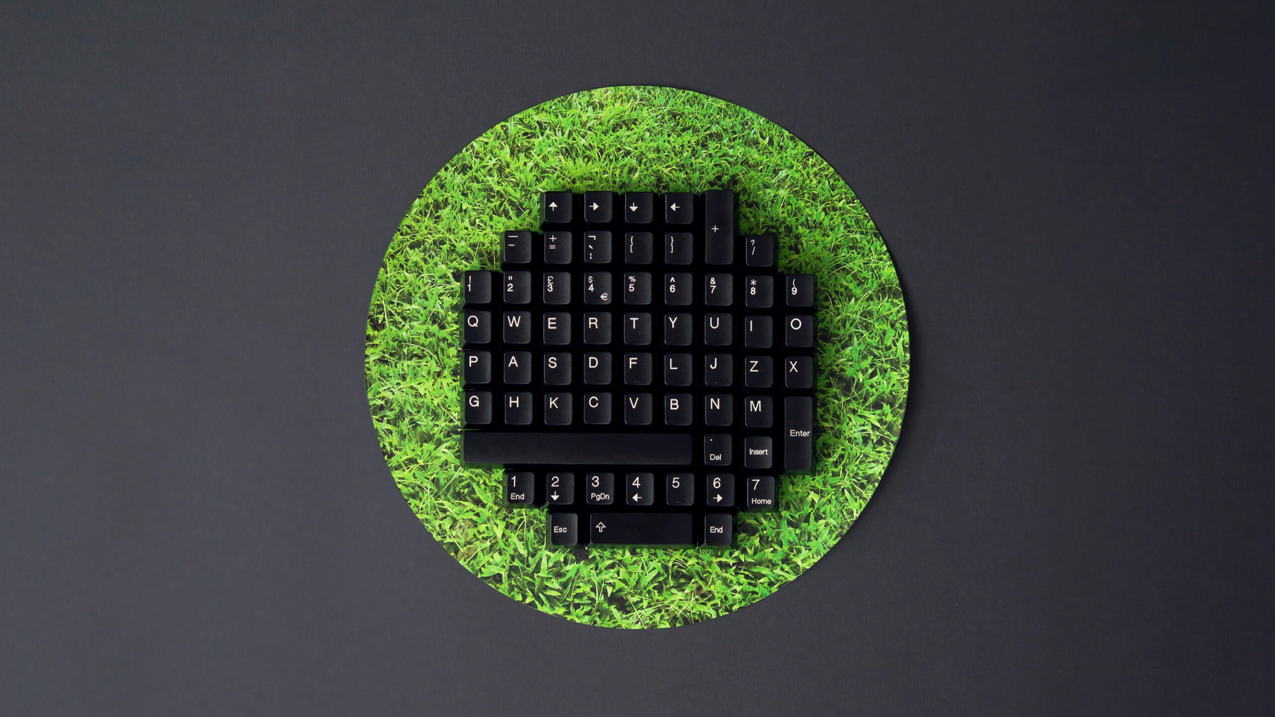 Picture of a circular keyboard juxtaposed against a slightly larger grass circle